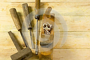 Carpenter tools on wooden table with sawdust. Craftperson workplace top view