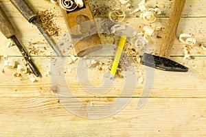 Carpenter tools on wooden table with sawdust. Craftperson workplace top view