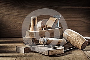 Carpenter tools woodworkers plane handsaw chisel mallet on vintage wood background photo