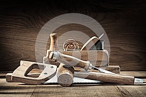 Carpenter tools woodworkers plane wooden mallet chisel handsaw on vintage wooden background photo