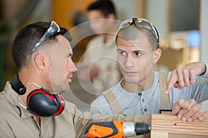 carpenter training apprentice to use plane