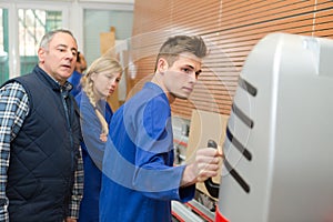 Carpenter training female apprentice to use plane