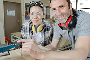 carpenter training female apprentice to use plane