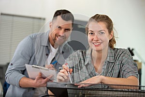 carpenter training female apprentice to use plane