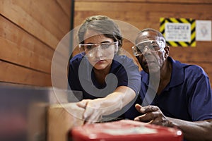 Carpenter Training Female Apprentice To Use Plane