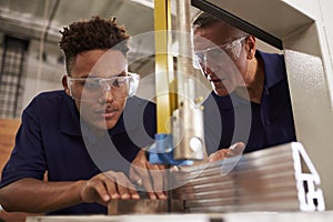 Carpenter Training Male Apprentice To Use Mechanized Saw photo