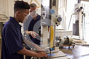 Carpenter Training Male Apprentice To Use Mechanized Saw