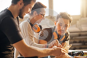 Carpenter with students in woodworking workshop