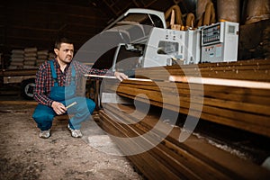 Carpenter in uniform at his workplace on sawmill