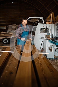 Carpenter in uniform measures board with caliper