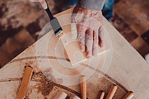 carpenter use a chisel to shapes a wooden plank.