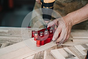 Carpenter use drill bit and centering dowel jig or pocket hole jig tool to make strong joints on wooden plate. woodworking concept