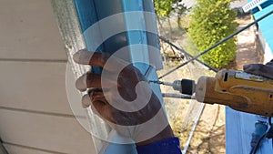 A carpenter uses a drill to shoot screws.