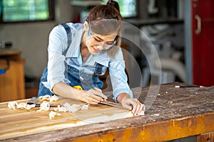 A carpenter uses equipment on a wooden table in a carpentry shop. woman working in a carpentry shop