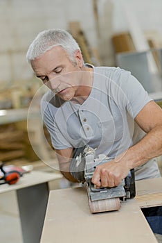 Carpenter using belt sander