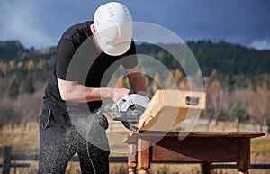 Carpenter using circular saw for cutting joist for building wooden frame house.