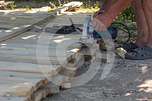 Carpenter using circular saw for cutting wooden boards