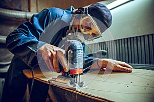 Carpenter using circular saw for cutting wooden boards.