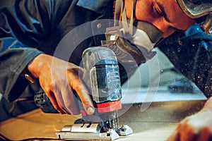 Carpenter using circular saw for cutting wooden boards.