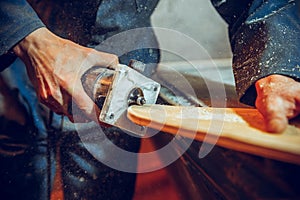 Carpenter using circular saw for cutting wooden boards.