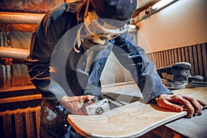 Carpenter using circular saw for cutting wooden boards.