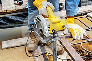 Carpenter using circular saw for cutting wooden boards with power tools, construction and home renovation, repair and construction