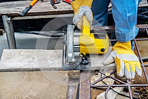 Carpenter using circular saw for cutting wooden boards with power tools, construction and home renovation, repair and construction