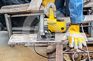 Carpenter using circular saw for cutting wooden boards with power tools, construction and home renovation, repair and construction