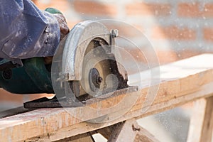 Carpenter using circular saw in loggers photo