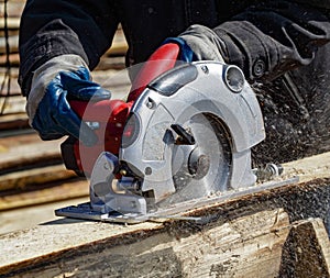 Carpenter Using Circular Saw works outdoors