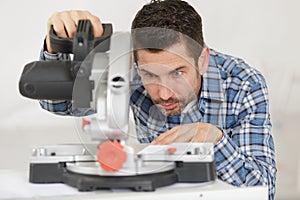 Carpenter using circular saw in workshop