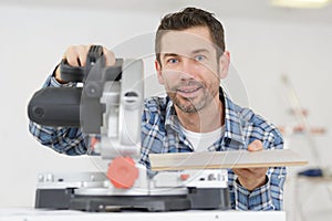 carpenter using circular saw in workshop