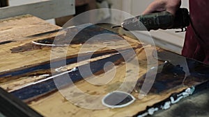 Carpenter using a cordless drill on a workbench, creating with purpose. Emphasizes the beauty of handcrafted woodwork in