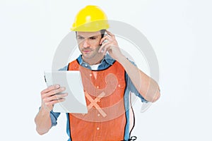 Carpenter using digital tablet and mobile phone