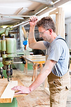 Carpenter using electric drill in carpentry