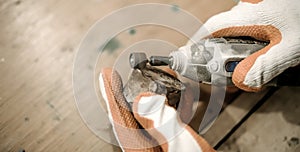 Carpenter using electric hand grinder