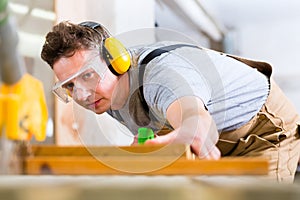 Carpenter using electric saw in carpentry