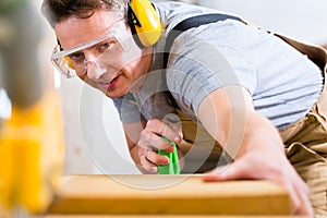 Carpenter using electric saw in carpentry