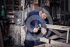 Carpenter using Hammer and Chisel in Workshop