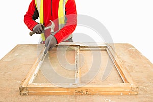 Carpenter using a hammer while repairing an old window frame sash