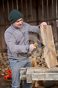 Carpenter using hatchet on walnut wood