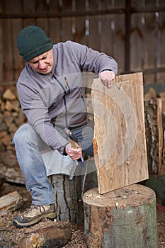 Carpenter using hatchet on walnut wood