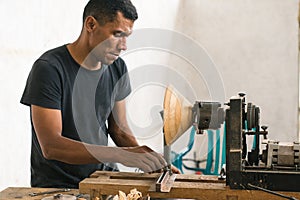 carpenter using his tools to make pieces of wood.Enterprising man doing his daily trades photo