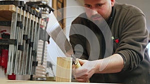 Carpenter using Japanese saw to cut wood in shop hardworking focused man concept