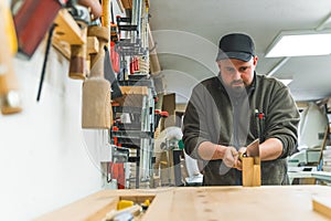 Carpenter using Japanese saw to cut wood in shop hardworking focused man concept
