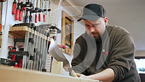 Carpenter using Japanese saw to cut wood in shop hardworking focused man at work