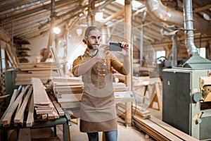 Carpenter using phone in the workshop