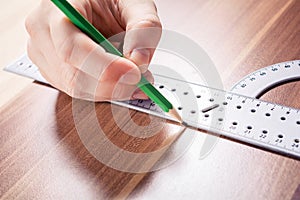 Carpenter Using A Protractor And Making A Mark At The Measuring Point With A Pencil On A Wooden Board