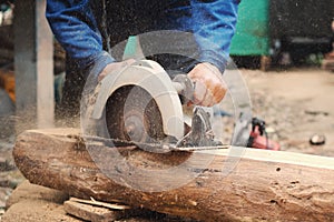 carpenter using saws cutting woods at construction photo