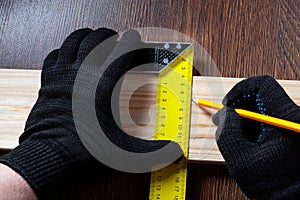 carpenter using Square ruler and pencil for measuring on wooden board. construction concept.